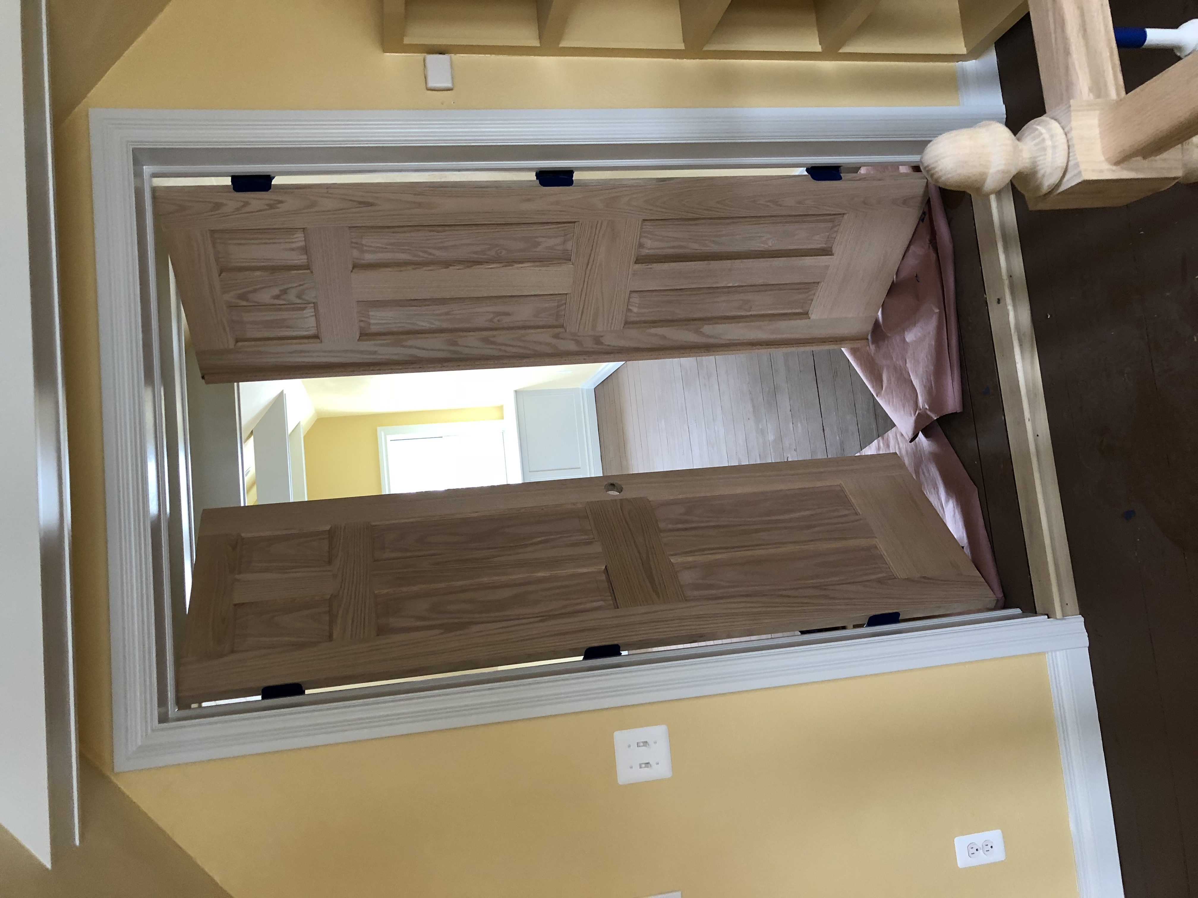 Detailed interior double doors with white trim and finished hardwood flooring